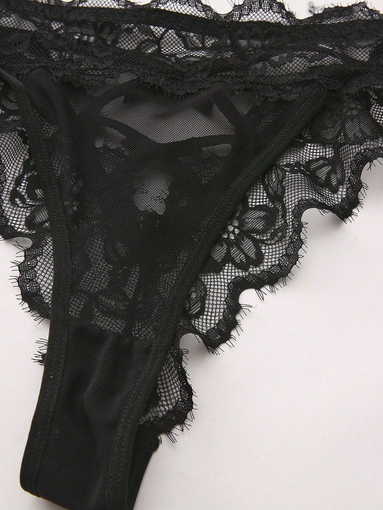 Women's low-rise lace mesh trim thong panties with sheer detailing, bow and knot accents, and plant pattern