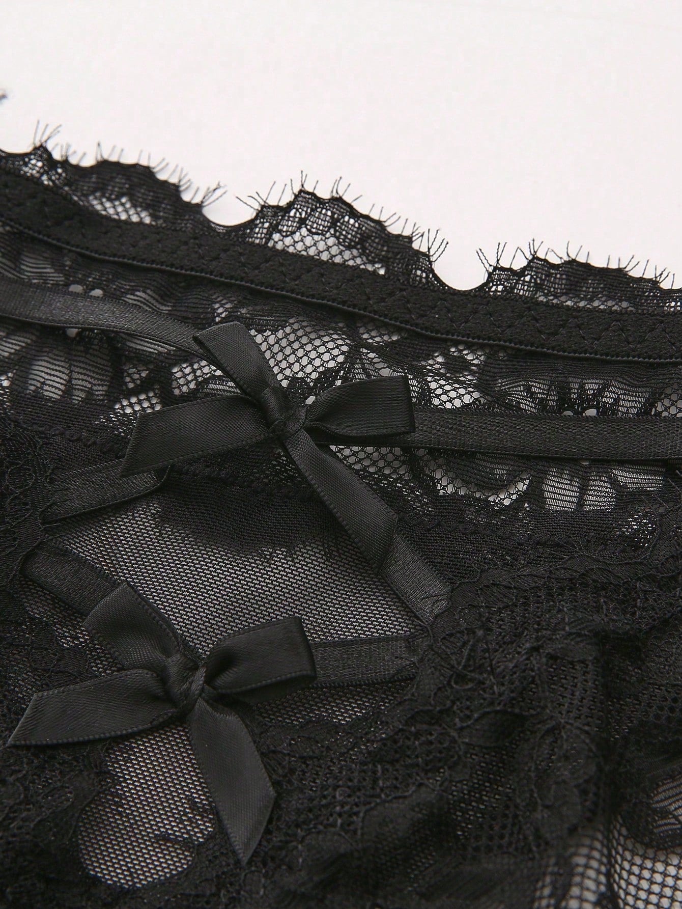 Women's low-rise lace mesh trim thong panties with sheer detailing, bow and knot accents, and plant pattern