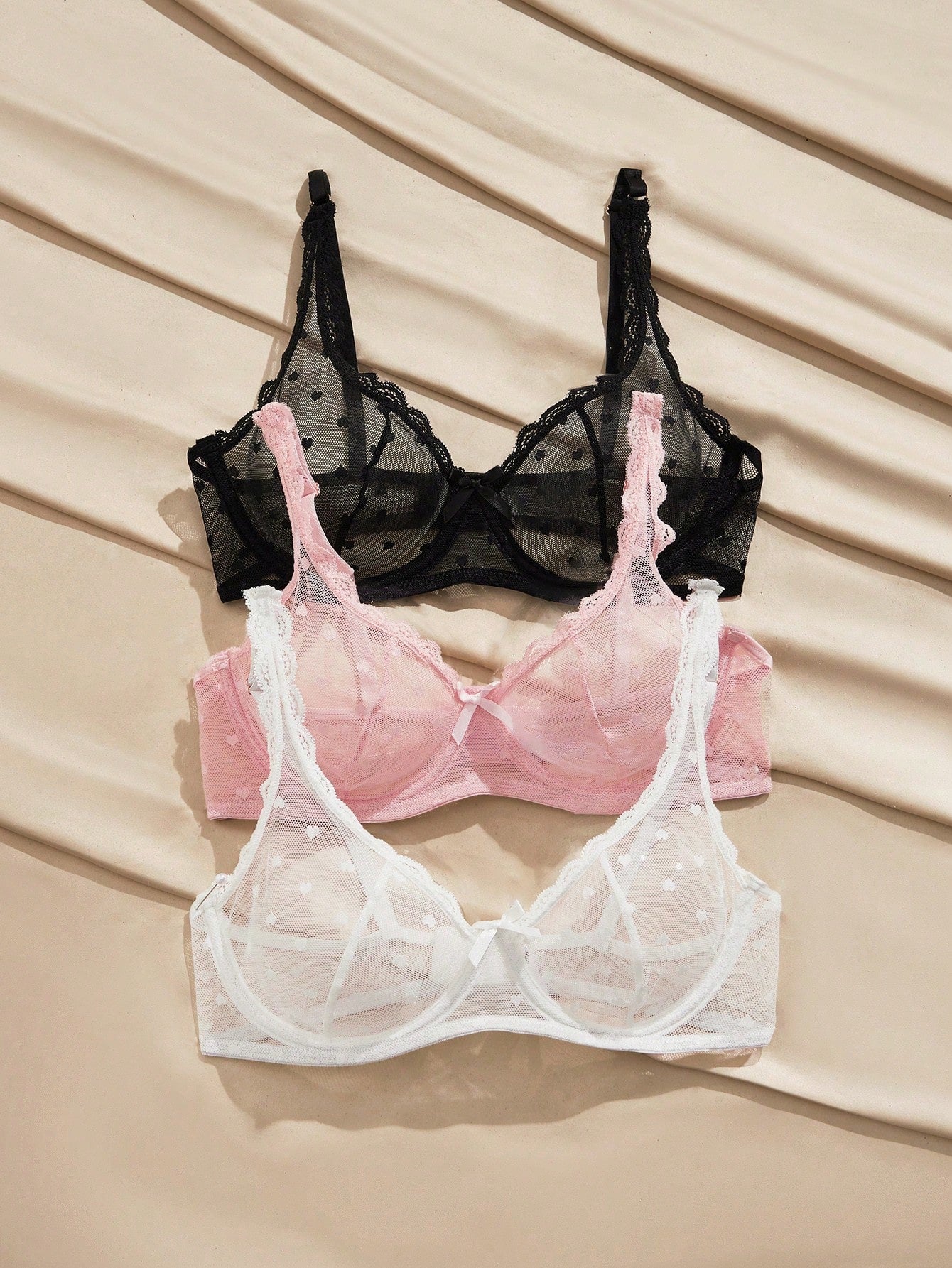 Women's solid color lace bra with sheer unlined design, bow detail, underwire support, and adjustable straps; romantic style push-up bralette for daily wear.