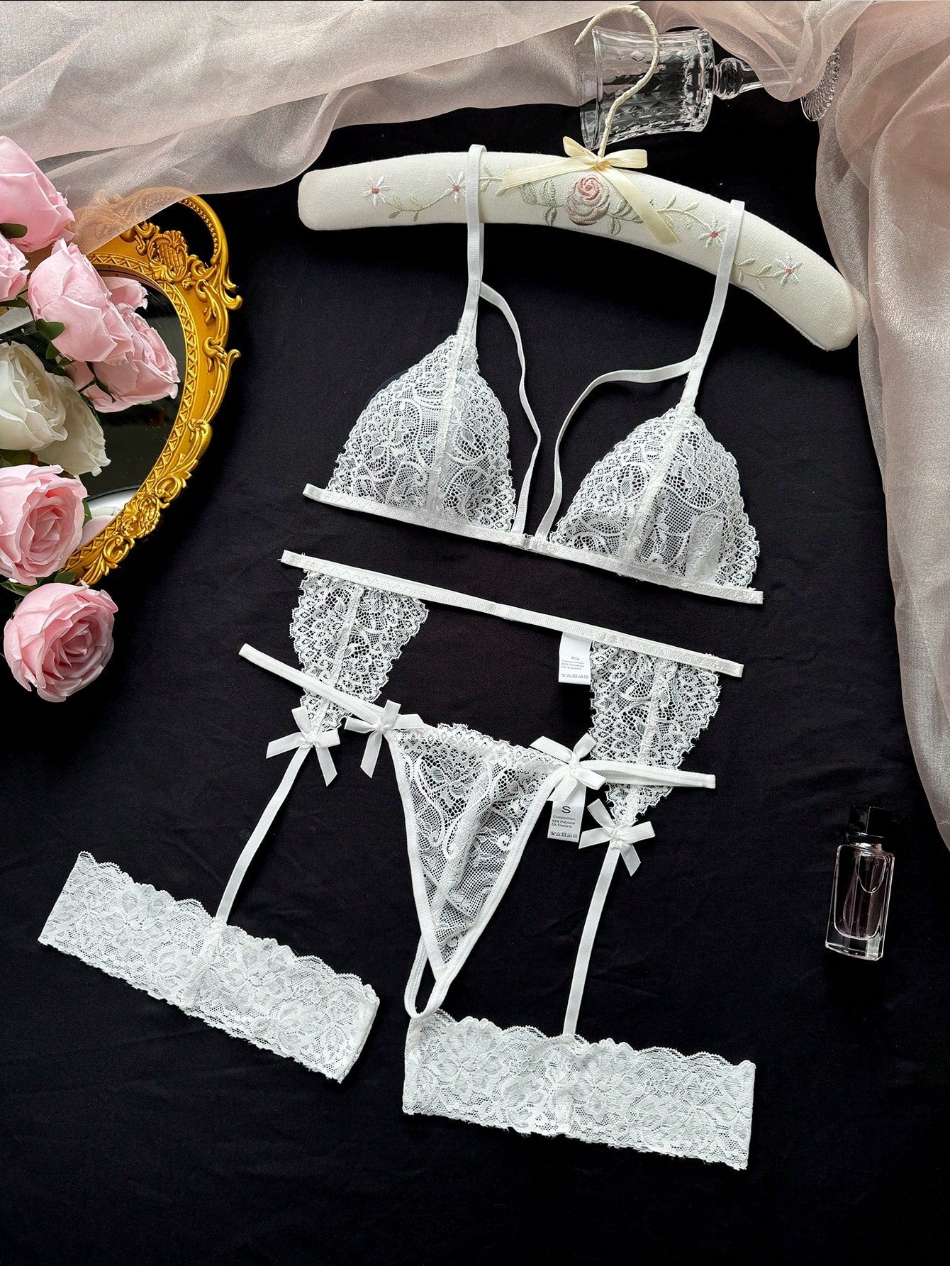 White women’s 3-piece lingerie set with sheer lace, bowknot decoration, cut-out details, spaghetti straps, and low-rise thong in a romantic style.