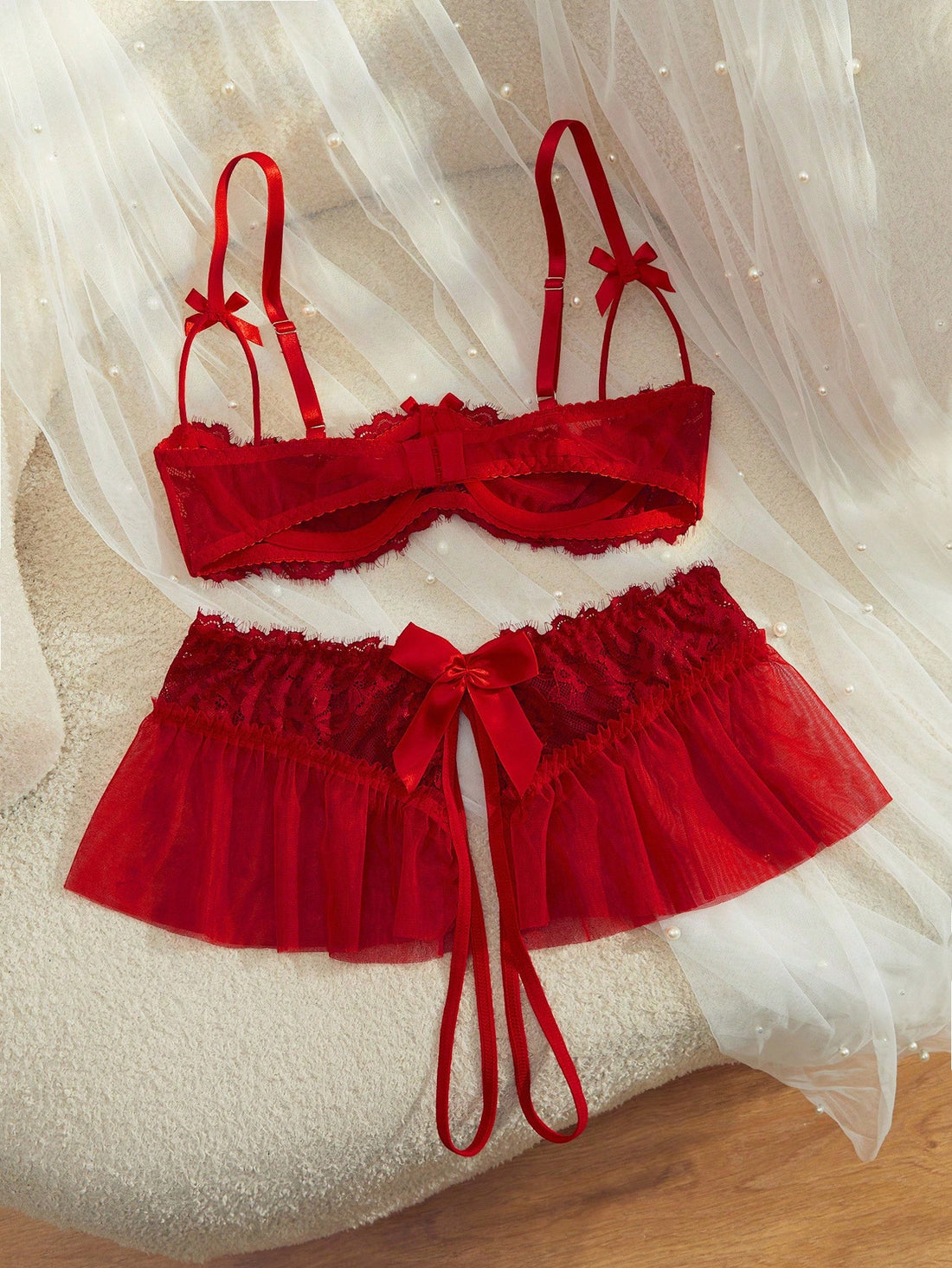 Semi-sheer red lace babydoll lingerie set featuring a flowy ruffle-hem skirt, spaghetti straps, underwire bralette top, and matching low-rise thong.