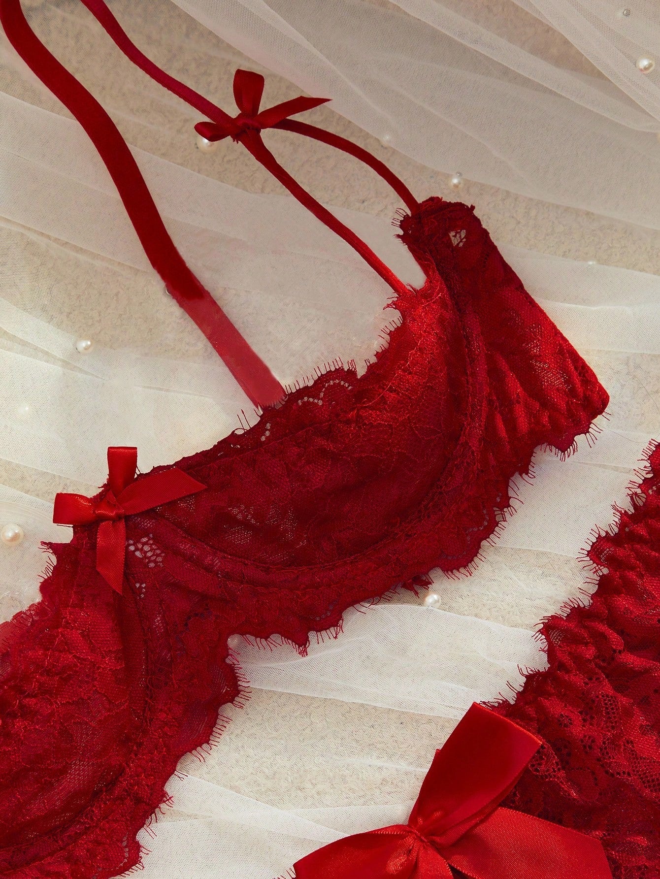 Semi-sheer red lace babydoll lingerie set featuring a flowy ruffle-hem skirt, spaghetti straps, underwire bralette top, and matching low-rise thong.