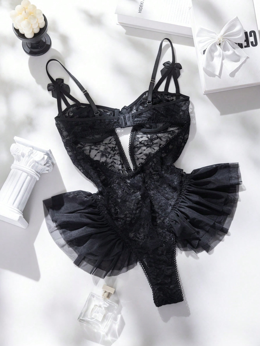 Women’s butterfly lace and mesh lingerie jumpsuit with ruffled trim, underwire cups, bow detail, cut-out accents, sheer fabric, and adjustable spaghetti straps.