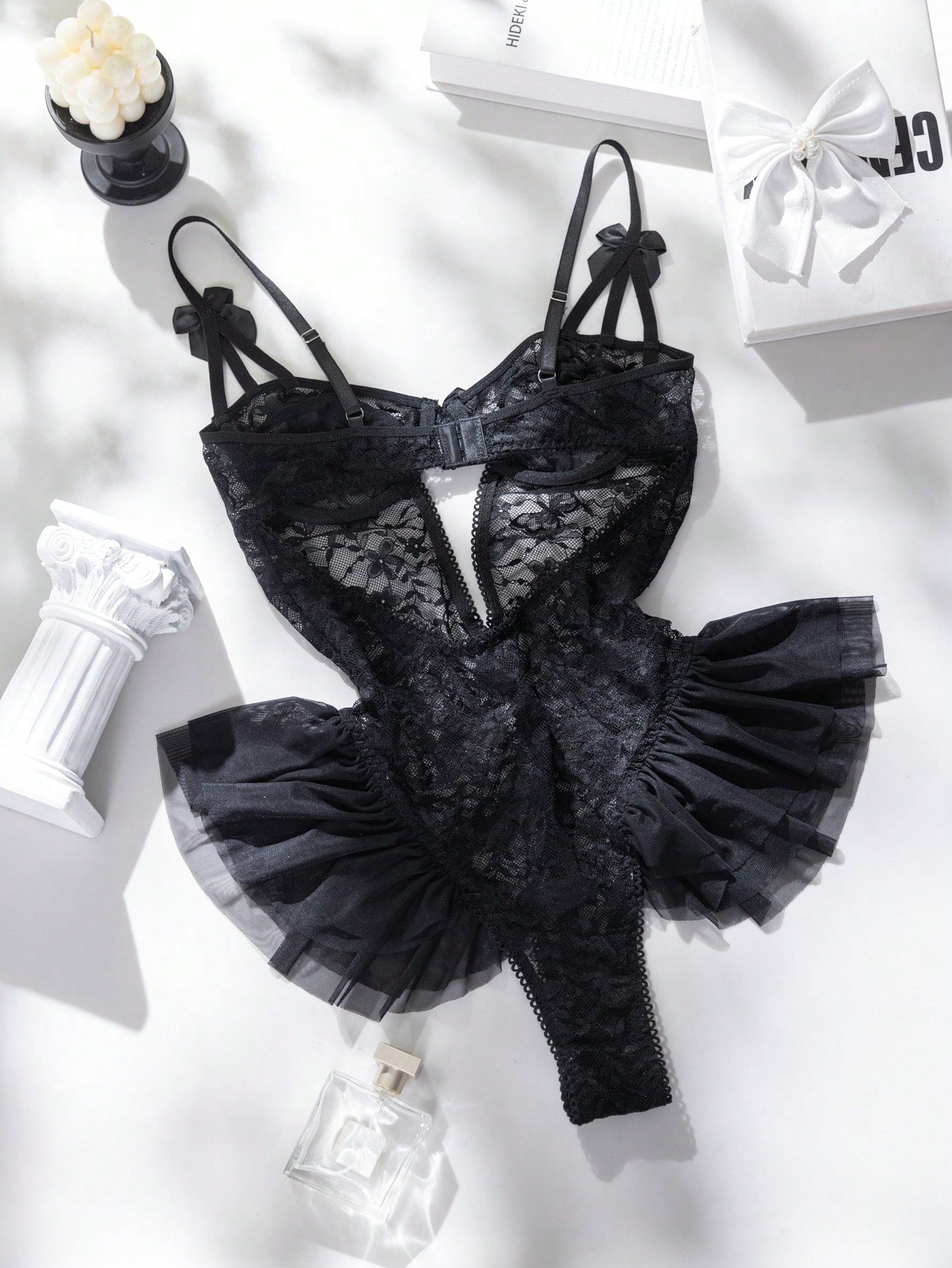 Women’s butterfly lace and mesh lingerie jumpsuit with ruffled trim, underwire cups, bow detail, cut-out accents, sheer fabric, and adjustable spaghetti straps.