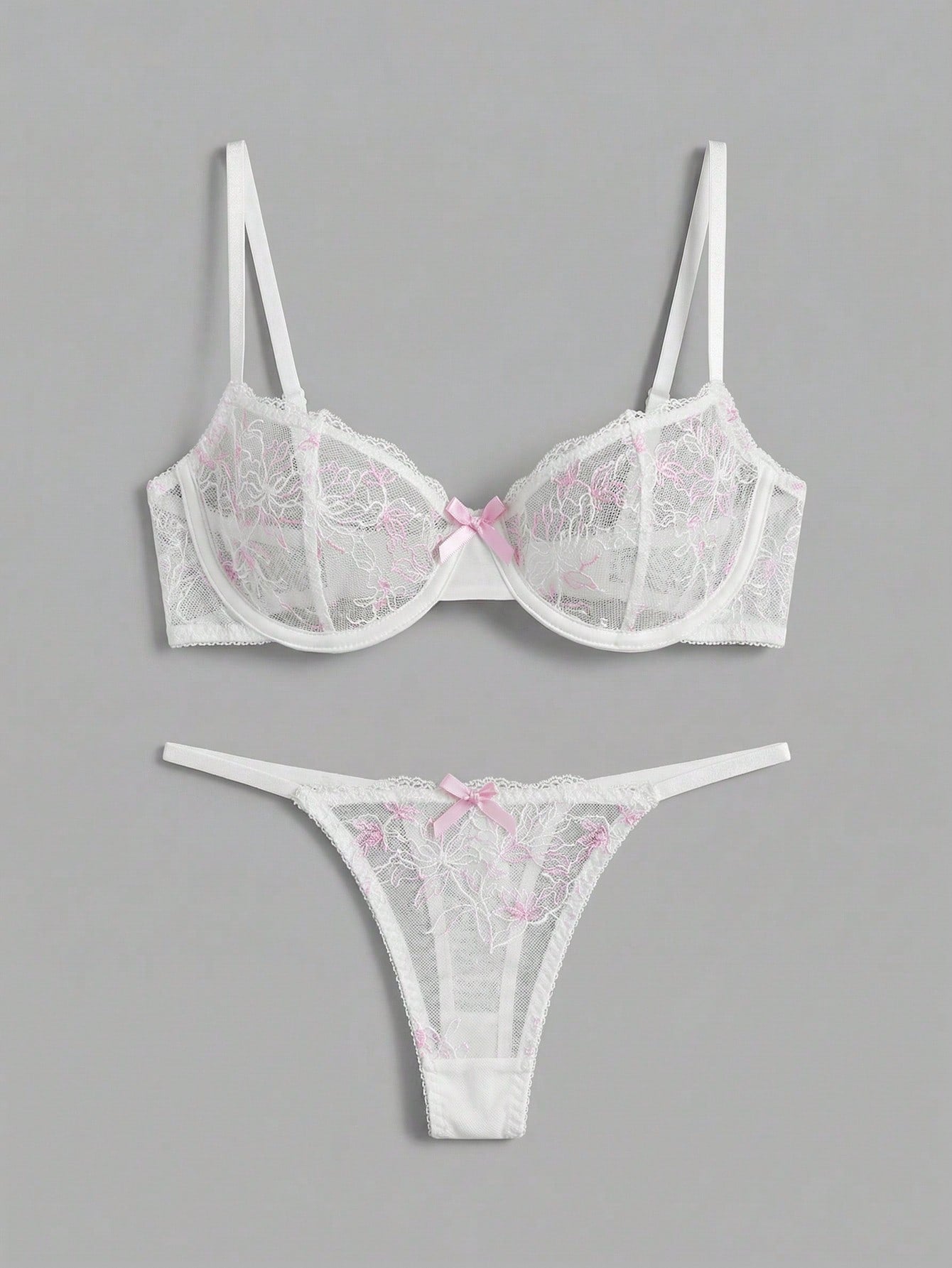 Two-piece pink lingerie set featuring a sheer mesh underwire bra with floral embroidery and adjustable straps, paired with a matching low-rise thong.
