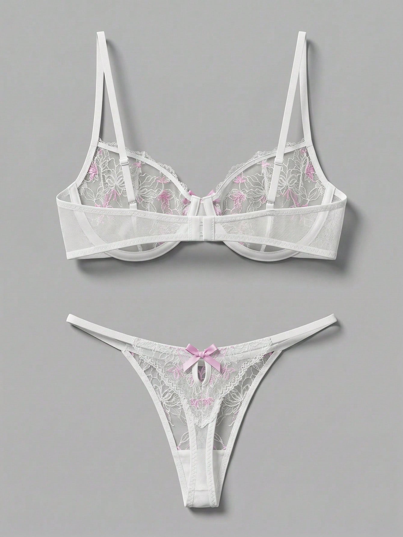 Two-piece pink lingerie set featuring a sheer mesh underwire bra with floral embroidery and adjustable straps, paired with a matching low-rise thong.