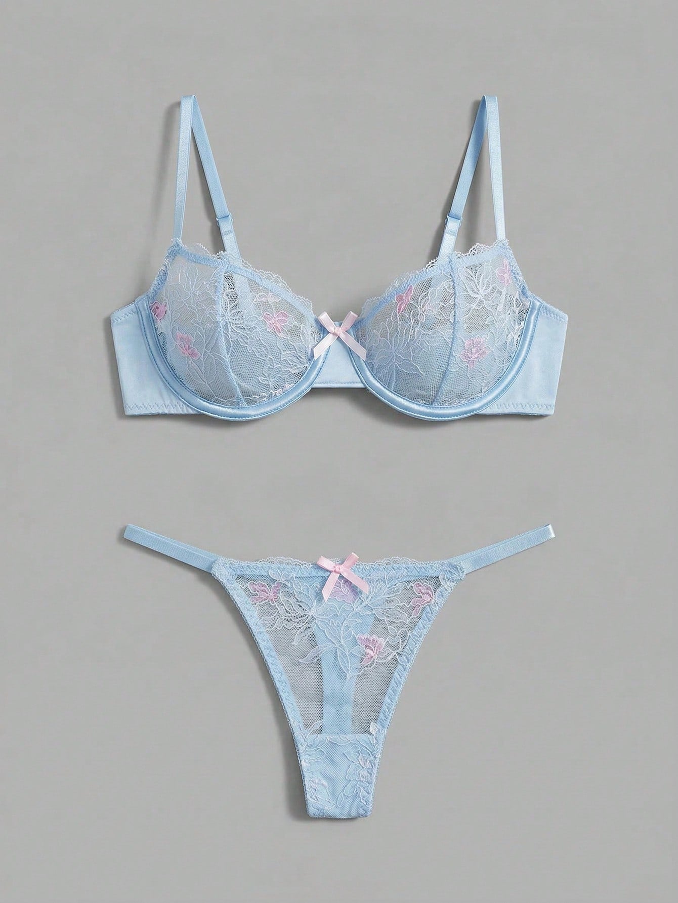 Two-piece pink lingerie set featuring a sheer mesh underwire bra with floral embroidery and adjustable straps, paired with a matching low-rise thong.