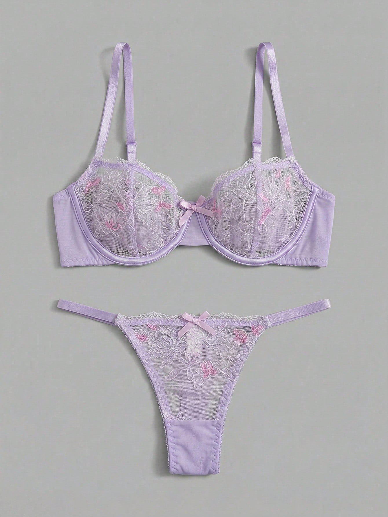 Two-piece pink lingerie set featuring a sheer mesh underwire bra with floral embroidery and adjustable straps, paired with a matching low-rise thong.