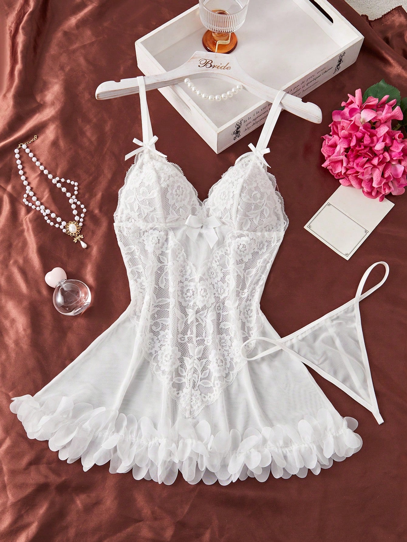 2-piece romantic lingerie set featuring a lace and mesh slip dress with spaghetti straps and matching thong, designed in a short length with bow and contrast lace details; available in white and burgundy.