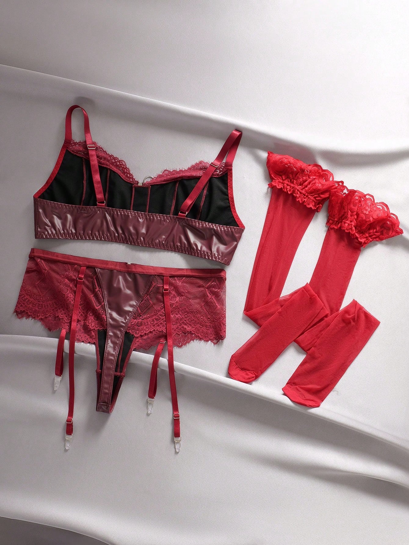 Three-piece lingerie set featuring a wireless spaghetti-strap bra with zipper and contrast lace splice details, a high-rise thong panty, and matching stockings in a punk-inspired style.