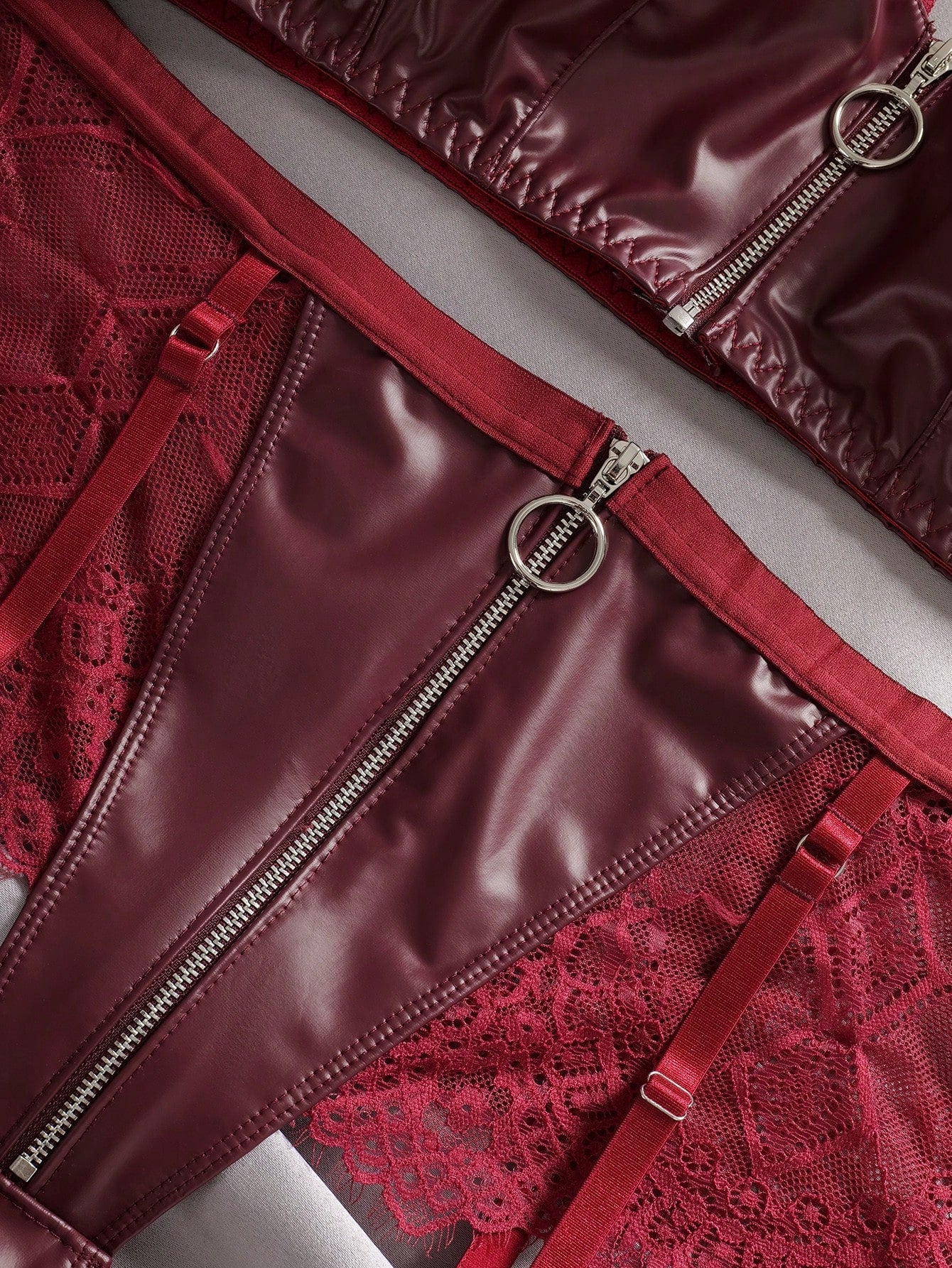 Three-piece lingerie set featuring a wireless spaghetti-strap bra with zipper and contrast lace splice details, a high-rise thong panty, and matching stockings in a punk-inspired style.
