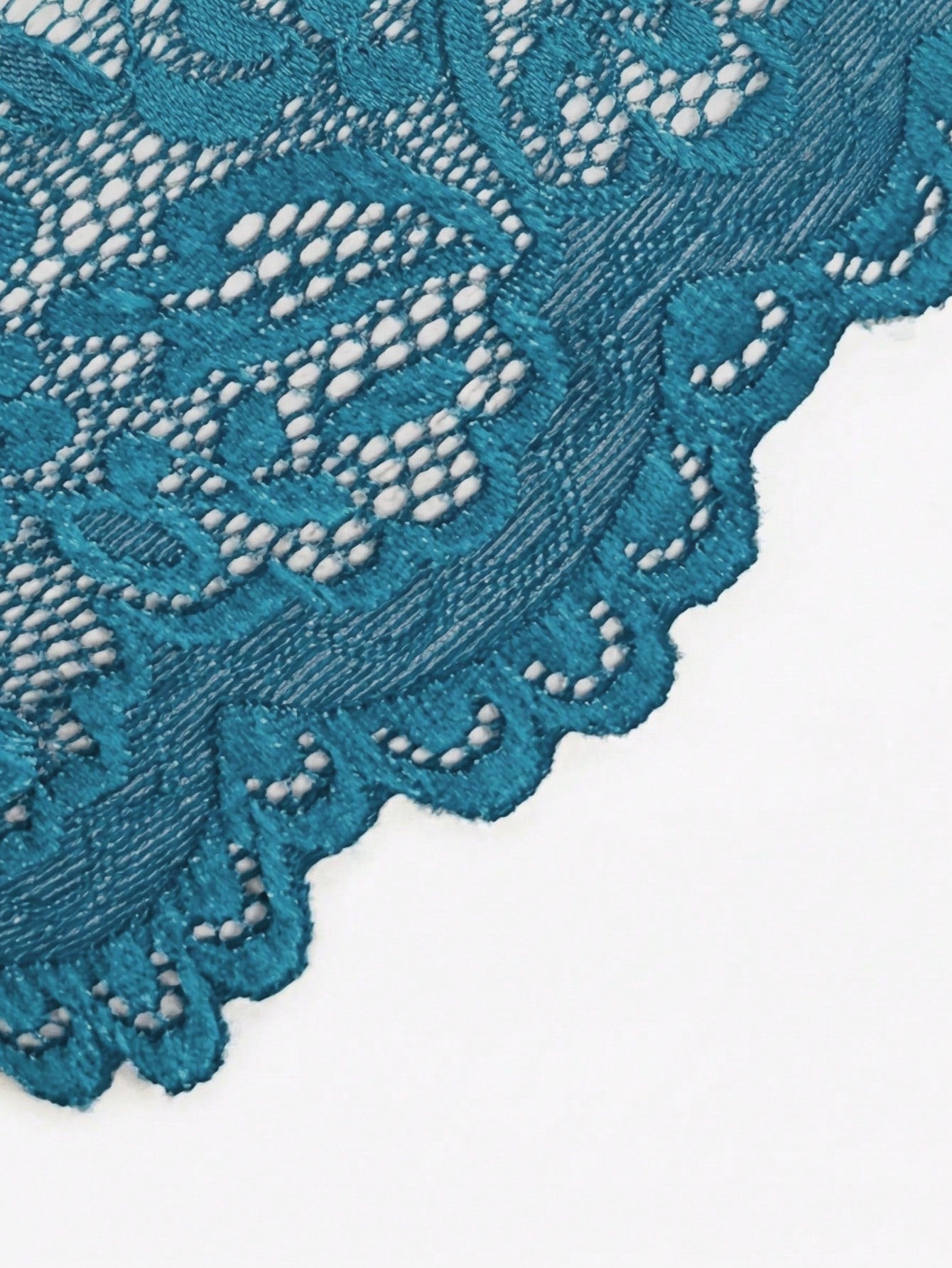 Teal blue floral lace crotchless teddy bodysuit lingerie with scallop trim, halter neckline, crossback straps, sheer unlined design, triangle cups, and thong-style low-rise bottom.
