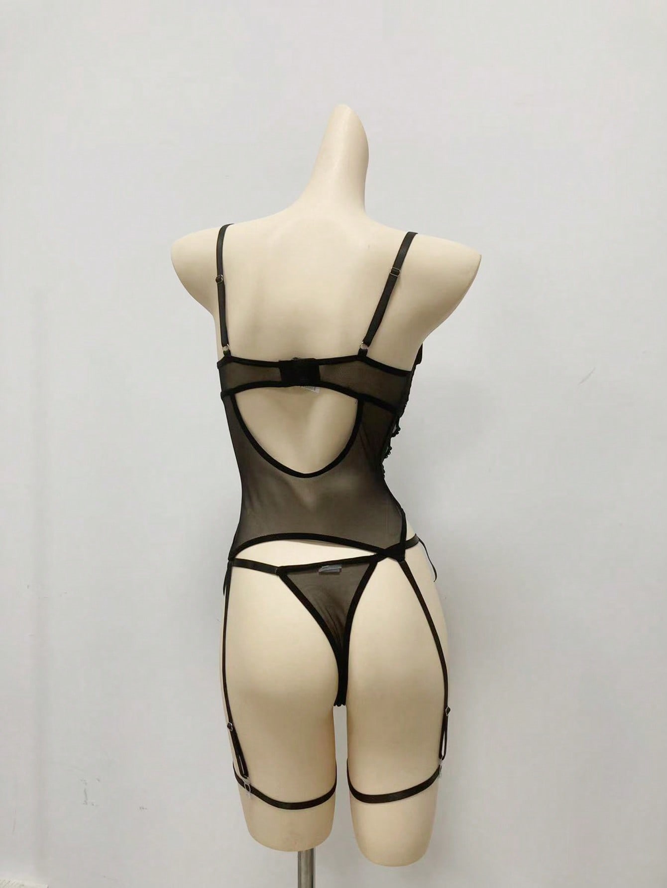 Women’s 4-piece lingerie set featuring lace and mesh panel design with tie-front detail, underwire camisole-style bra with adjustable spaghetti straps, and matching low-rise V-string panties.