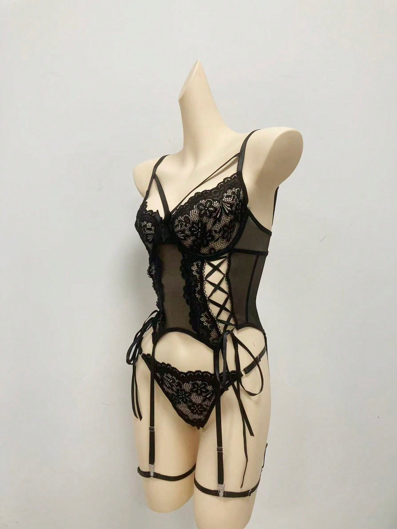 Women’s 4-piece lingerie set featuring lace and mesh panel design with tie-front detail, underwire camisole-style bra with adjustable spaghetti straps, and matching low-rise V-string panties.