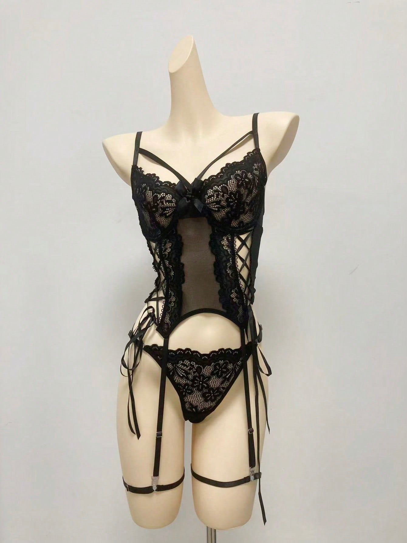 Women’s 4-piece lingerie set featuring lace and mesh panel design with tie-front detail, underwire camisole-style bra with adjustable spaghetti straps, and matching low-rise V-string panties.