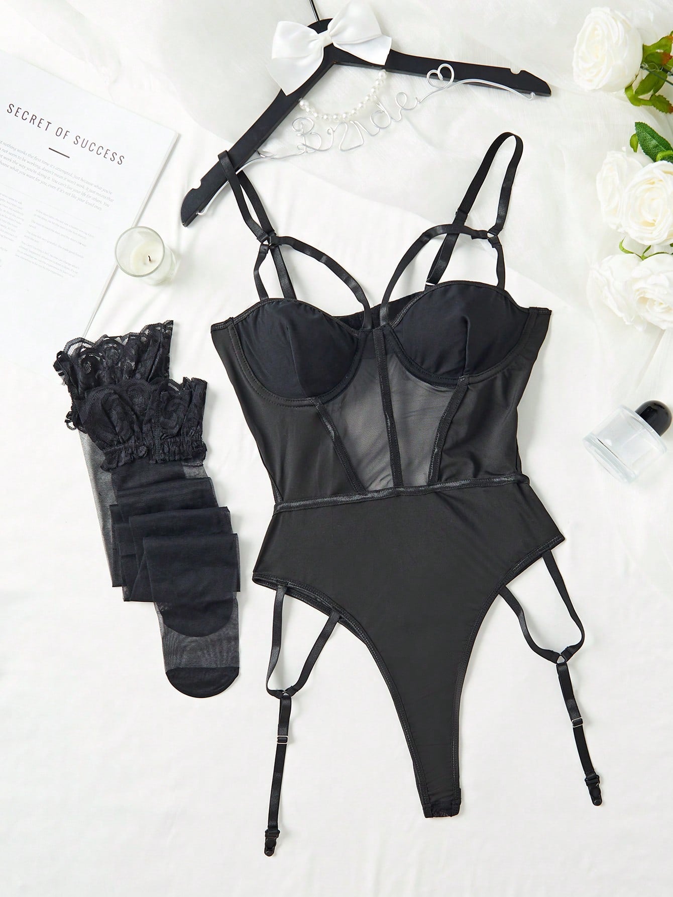 Black floral lace and mesh insert teddy bodysuit lingerie set with garter details and matching stockings, featuring spaghetti straps and a sheer design.