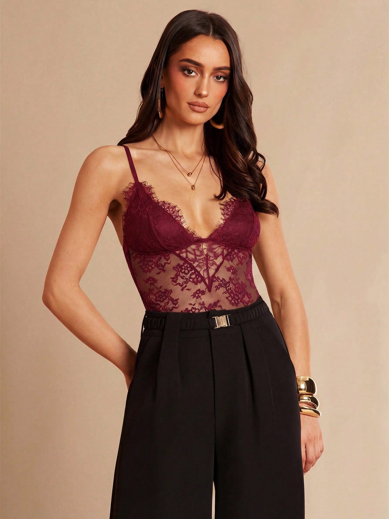 Women's black bodysuit with lace trim, sheer details, backless design, and spaghetti straps in a slim-fit cami style.