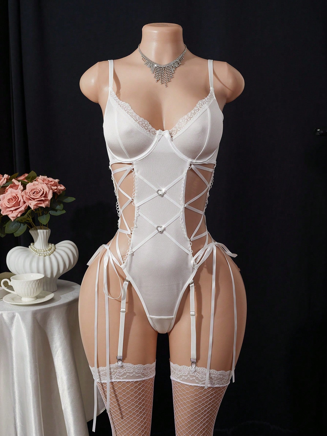Women’s 3-piece sexy lingerie set featuring a plain criss-cross lace-up bodystocking with cut-out detail and two matching stockings; sleeveless with spaghetti straps and a thong-style, low-rise fit. Available in Black, White, and Navy Blue.