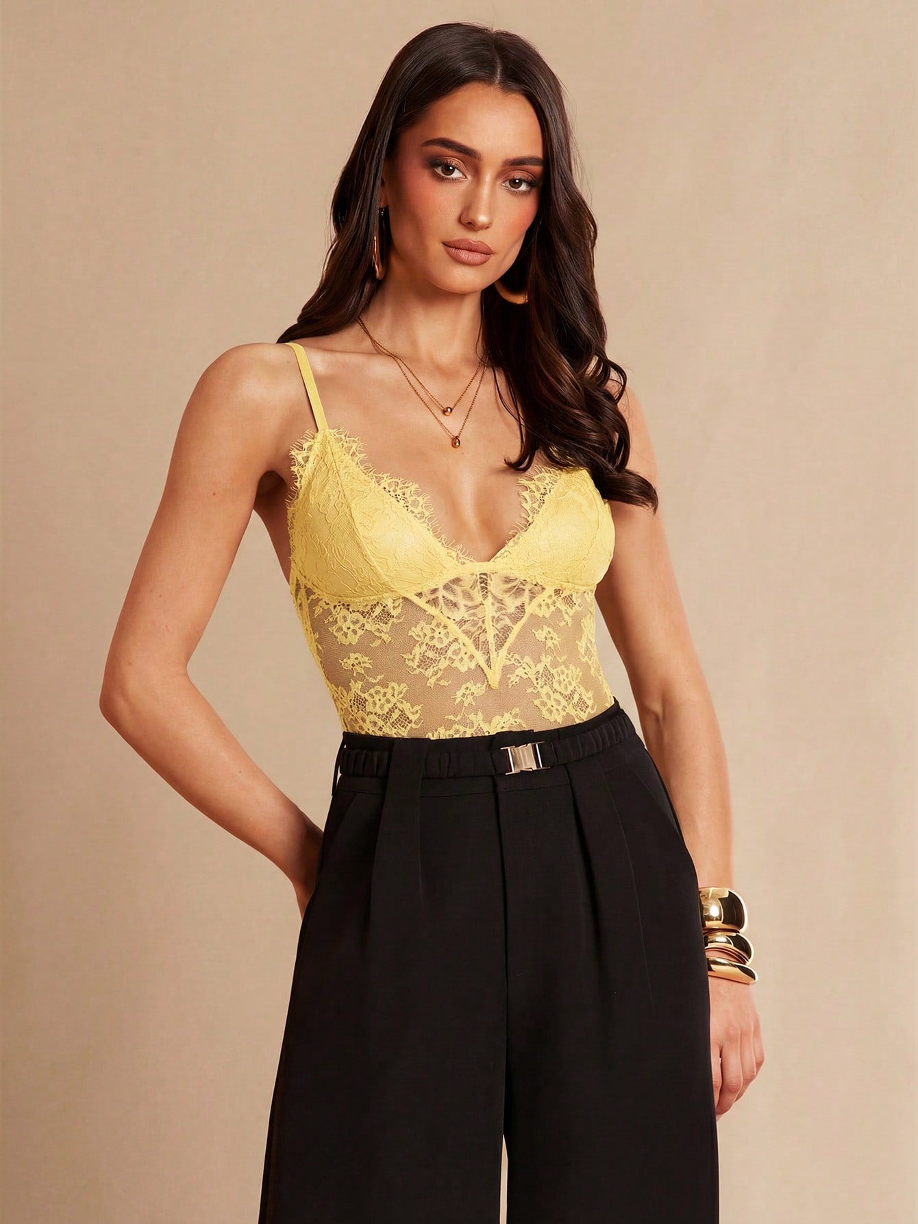 Women's black bodysuit with lace trim, sheer details, backless design, and spaghetti straps in a slim-fit cami style.
