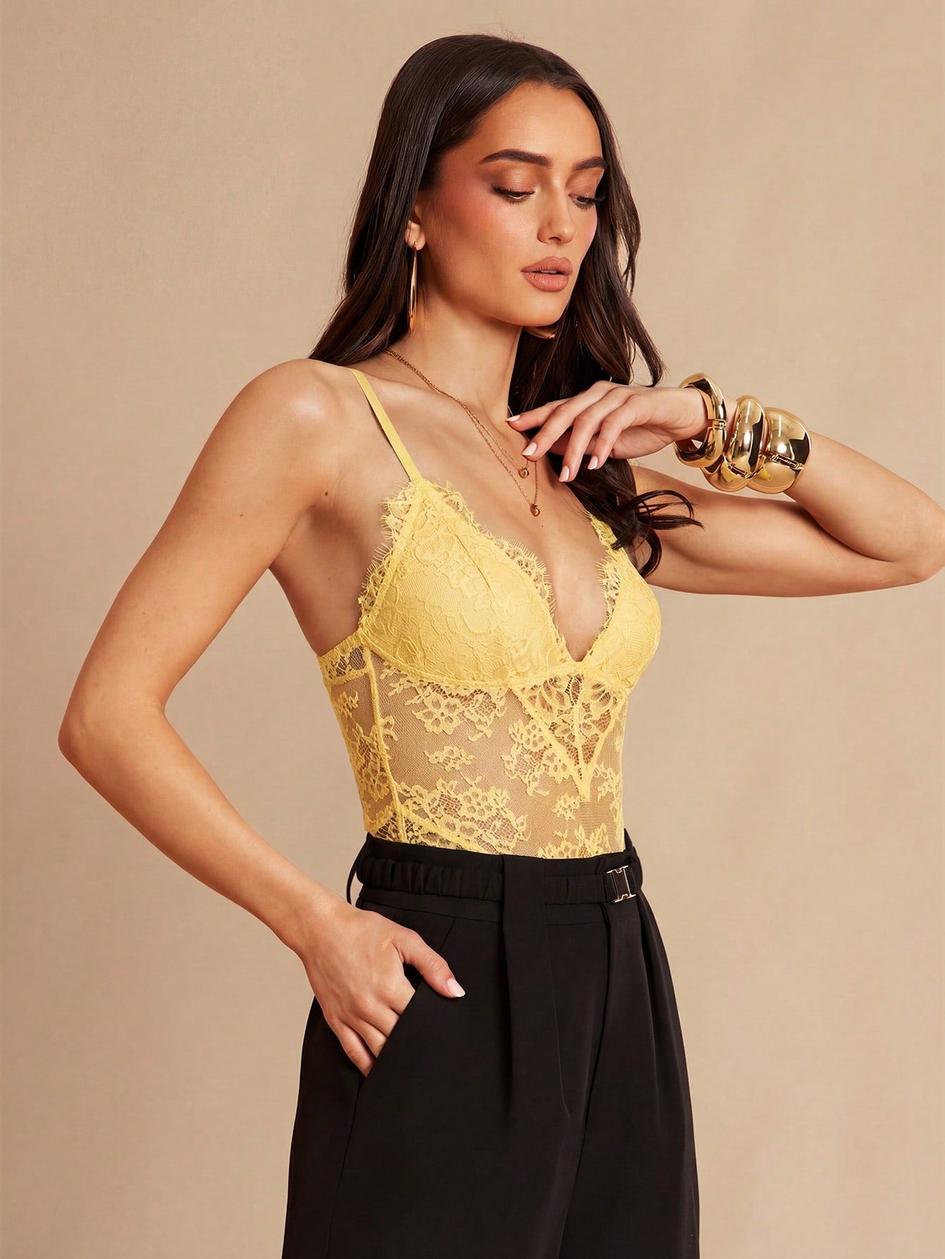 Women's black bodysuit with lace trim, sheer details, backless design, and spaghetti straps in a slim-fit cami style.