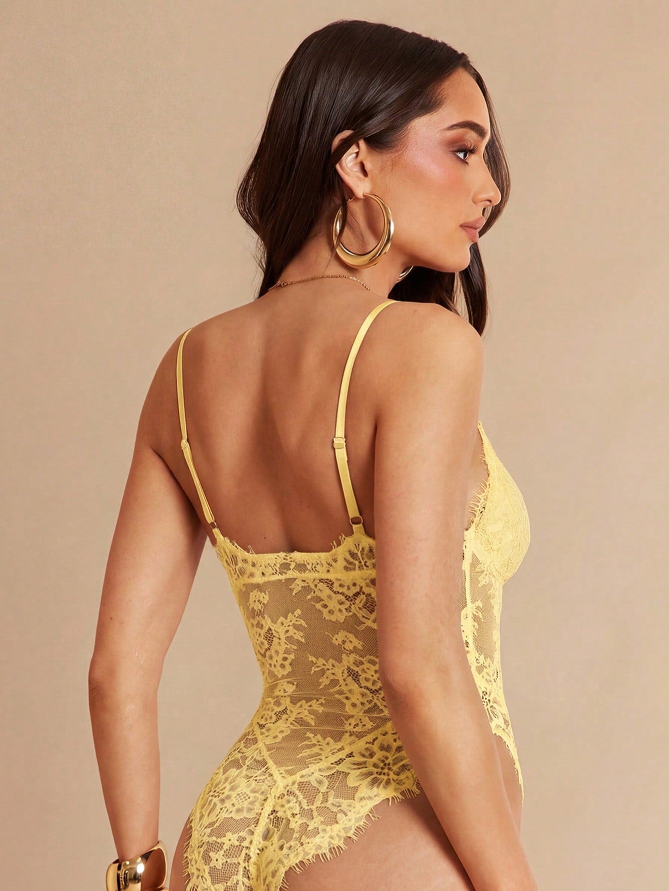 Women's black bodysuit with lace trim, sheer details, backless design, and spaghetti straps in a slim-fit cami style.
