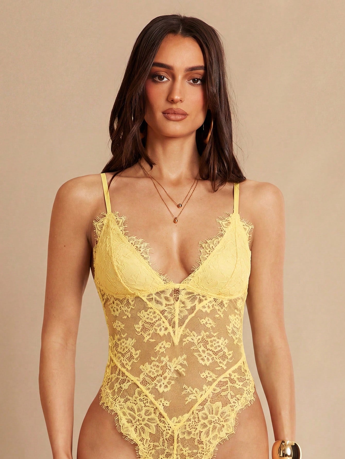 Women's black bodysuit with lace trim, sheer details, backless design, and spaghetti straps in a slim-fit cami style.