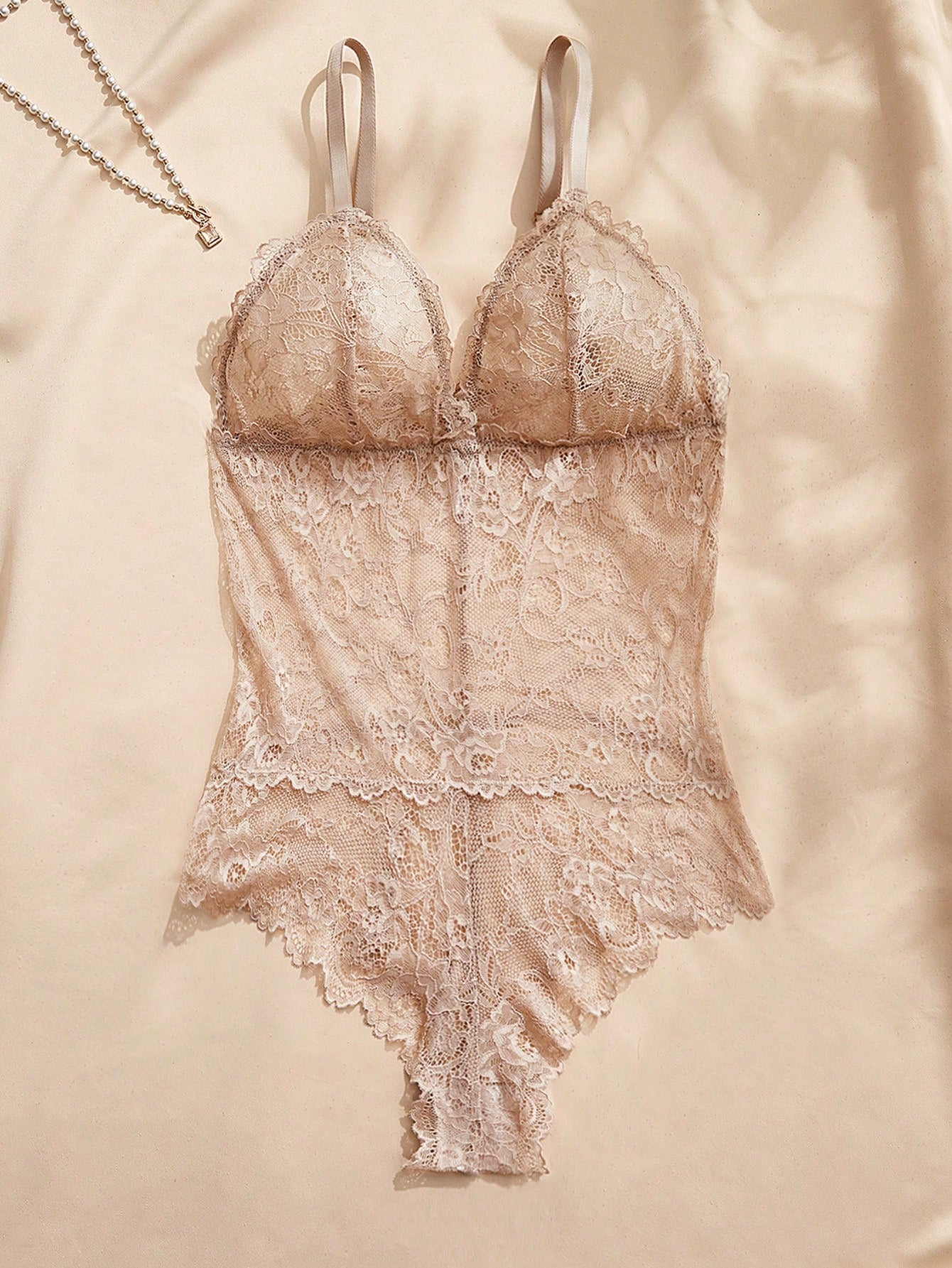 Women's black lace bodysuit with sheer contrast lace, backless design, spaghetti straps, and adjustable straps