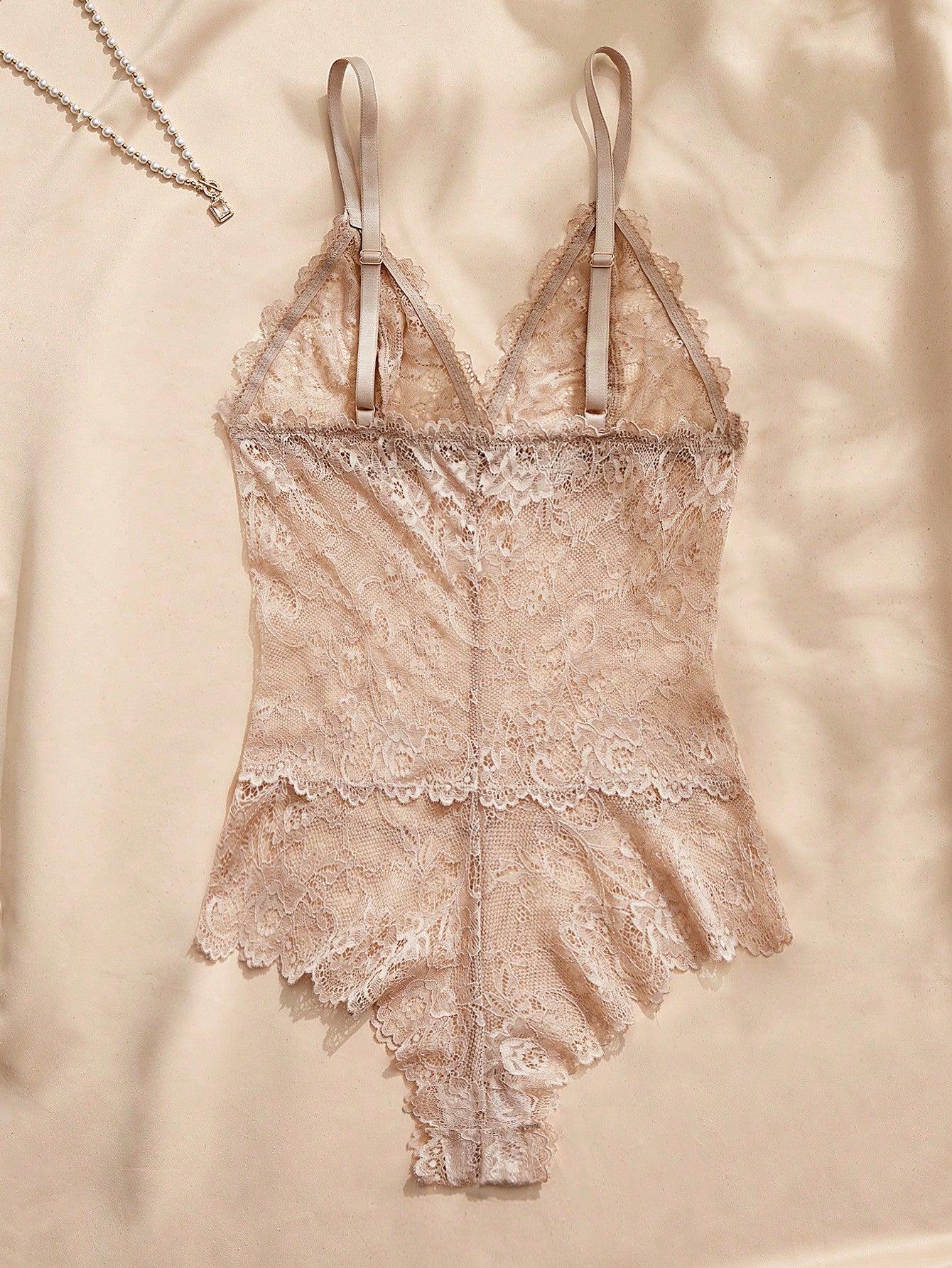 Women's black lace bodysuit with sheer contrast lace, backless design, spaghetti straps, and adjustable straps