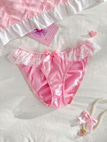 Women's pink low-rise triangle briefs with contrast lace, ruffle trim, bow detail, crisscross accents, and plant pattern