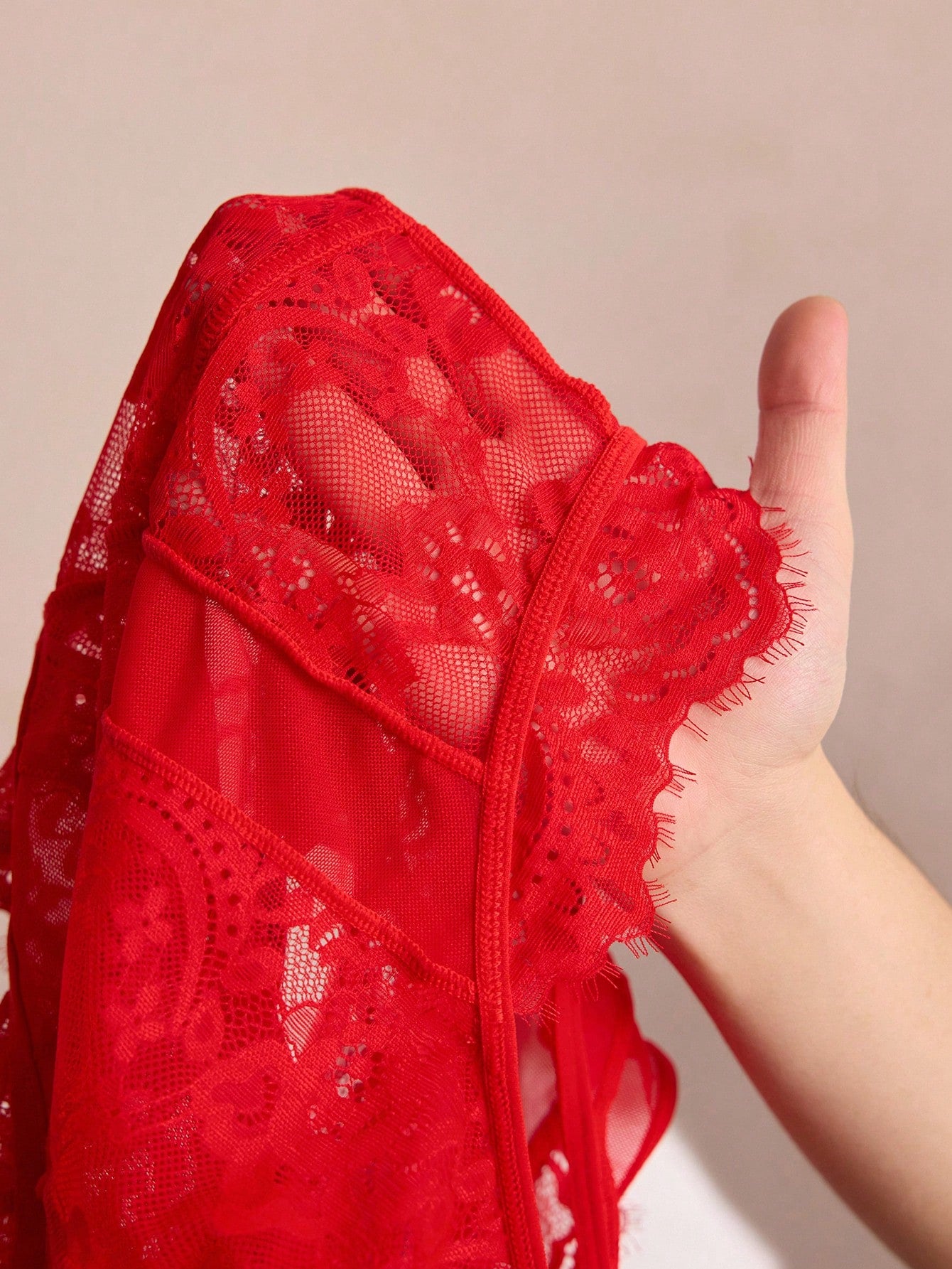 Women's red semi-sheer lace lingerie bodysuit with eyelash trim, plant pattern, sleeveless design, and brief panty cut