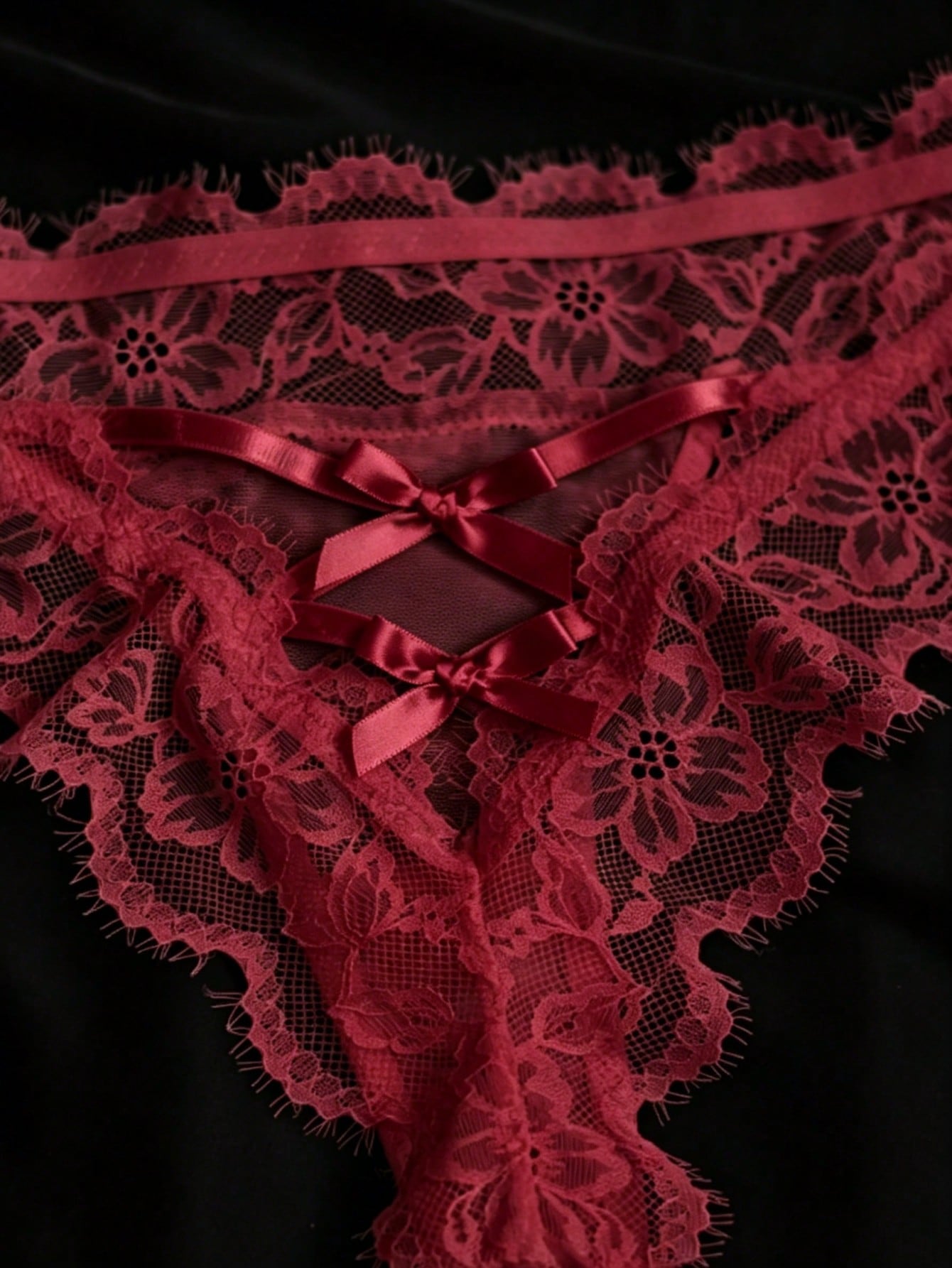 Women's low-rise lace mesh trim thong panties with sheer detailing, bow and knot accents, and plant pattern