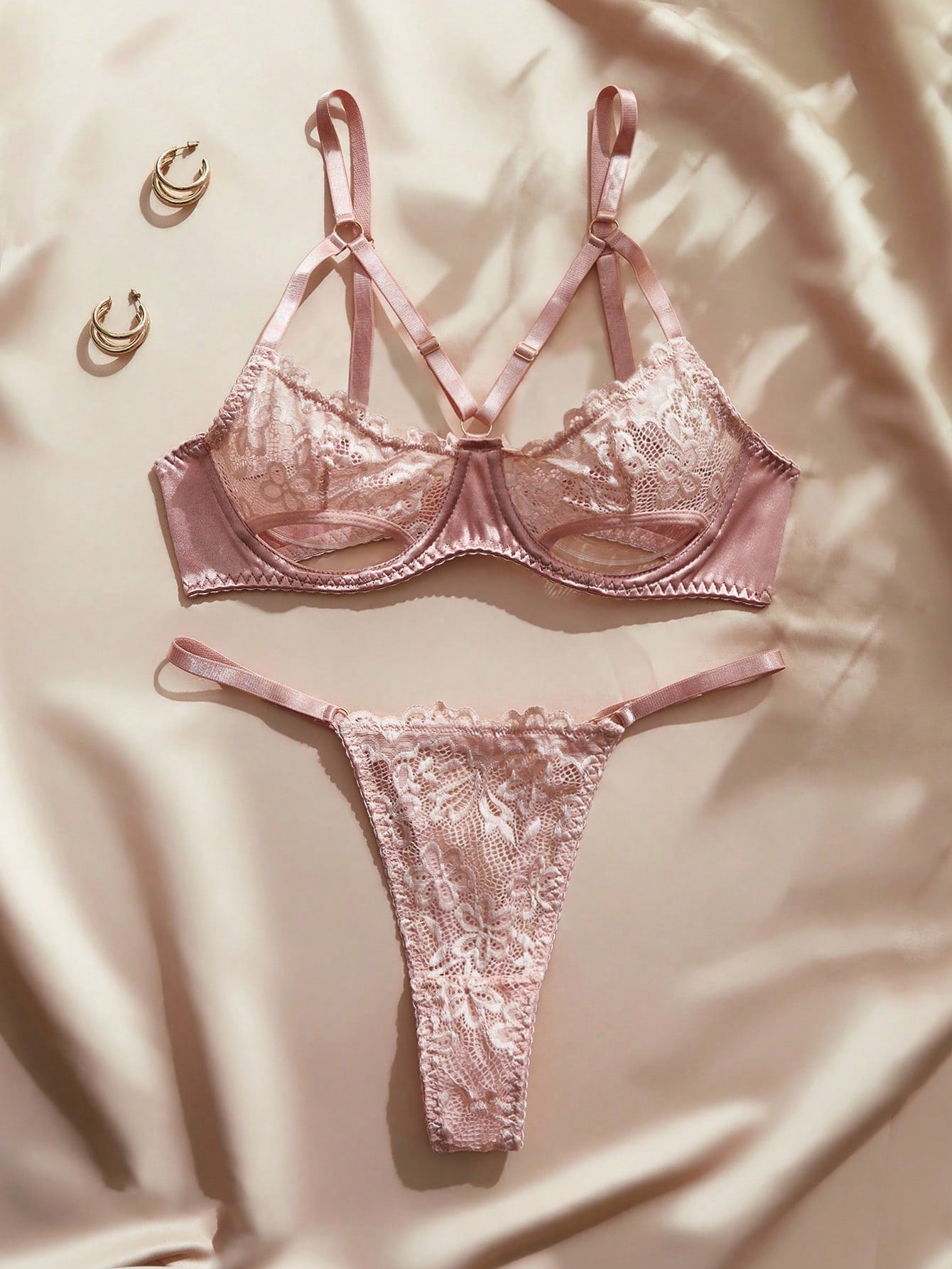 Pink French-style lingerie set featuring an underwire bra with adjustable straps and a low-rise thong with hollow-out detailing and plant pattern.